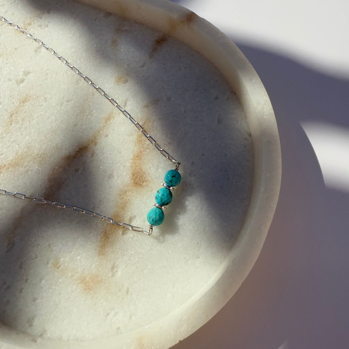 Necklace with turquoise beads on a marble surface