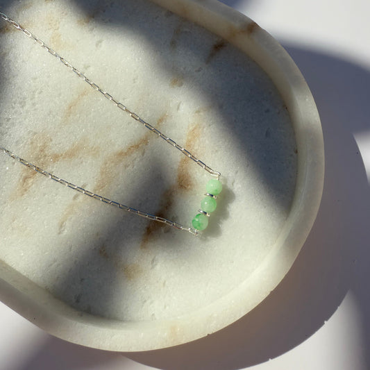 Silver necklace with chrysoprase beads on marble