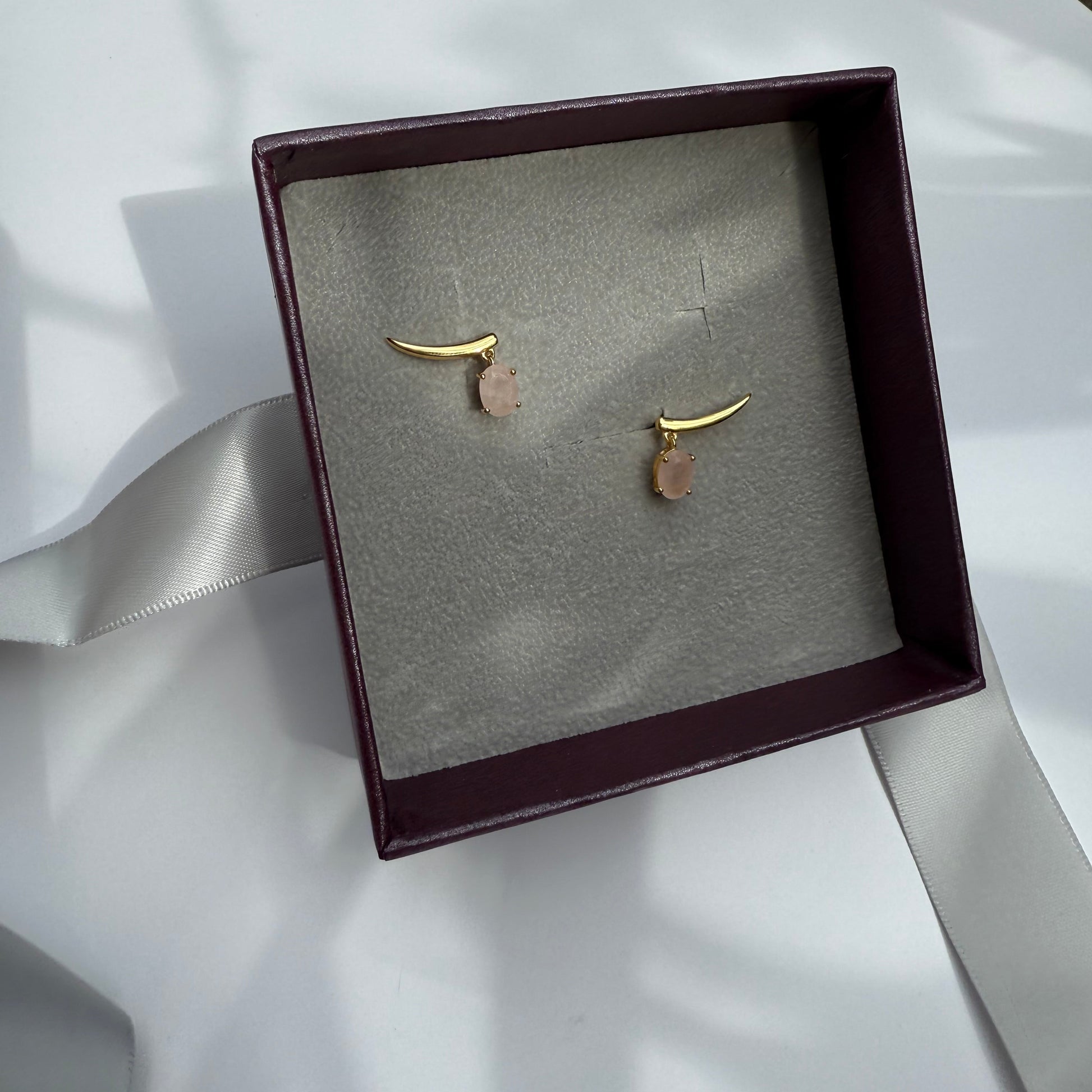 Pair of gold rose quartz climber earrings in a jewelry box 