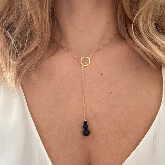 Wearing drop gold necklace black onyx