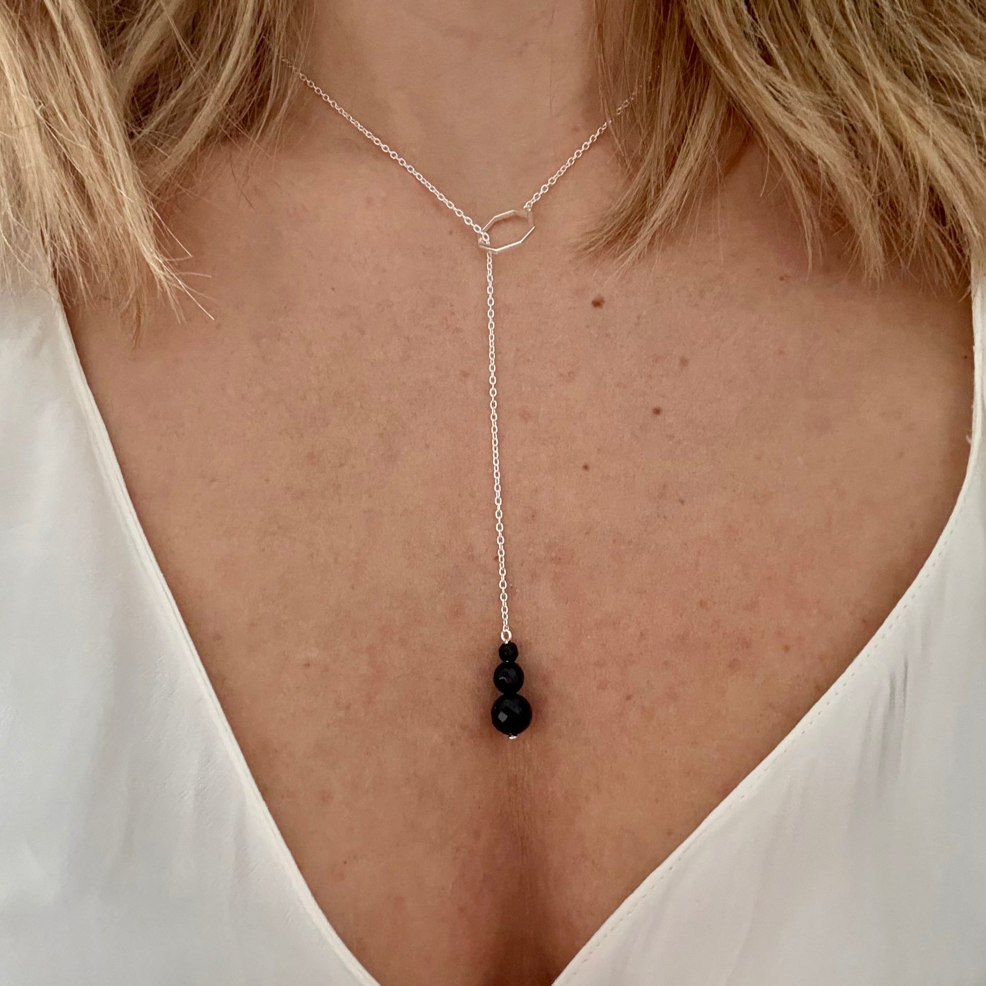 Wearing drop silver necklace black onyx