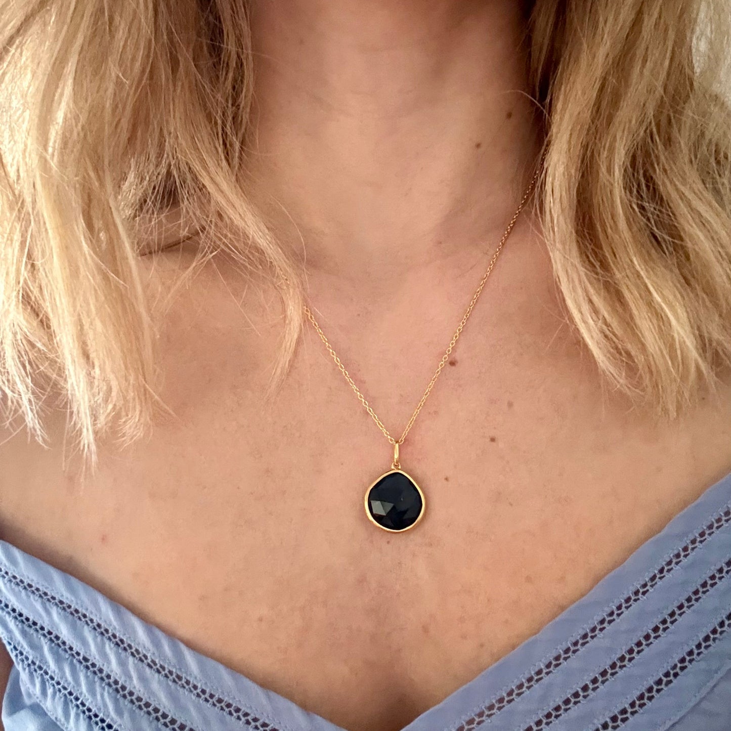 Wearing gold black onyx pear pendant 