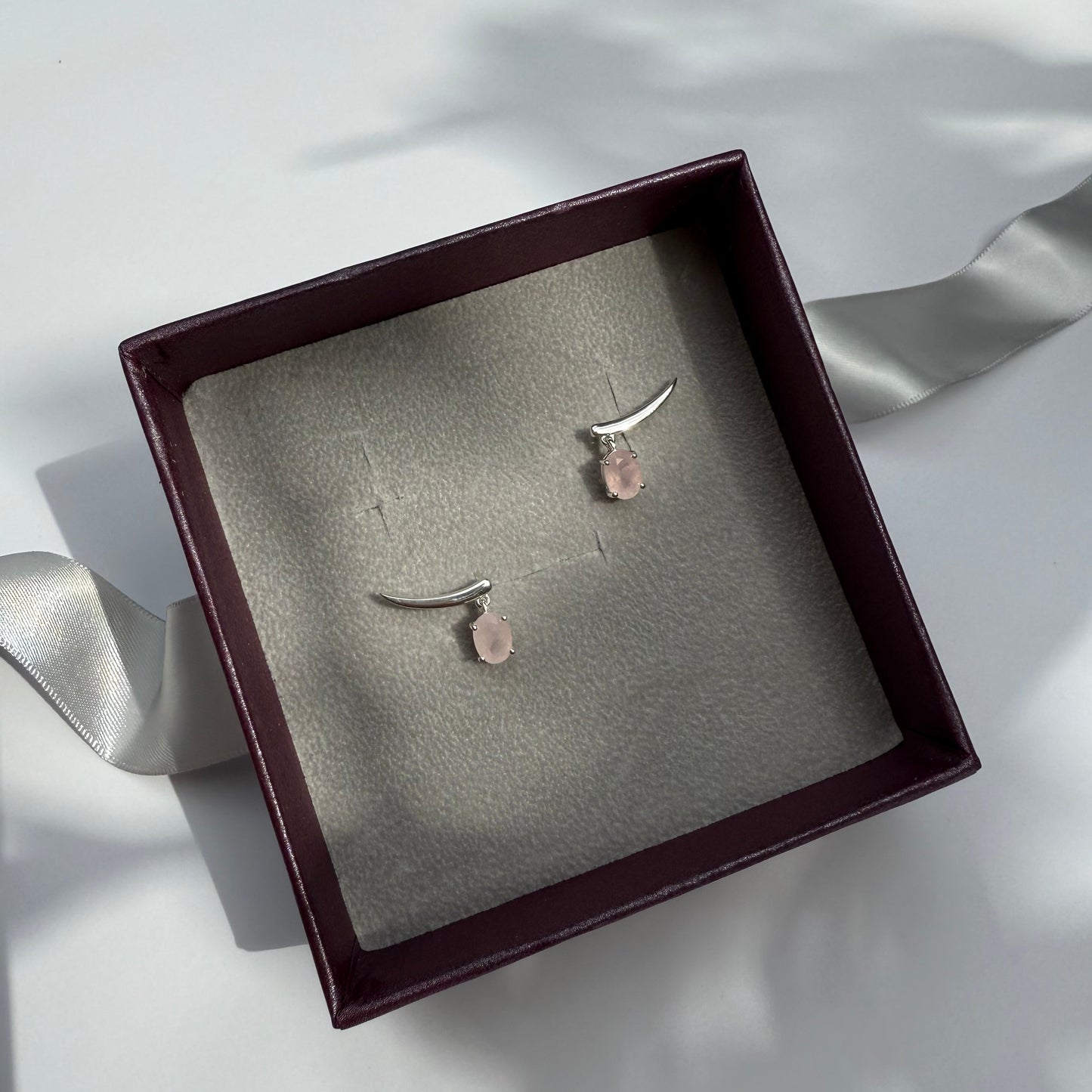 Pair of rose quartz climber earrings in a jewelry box 