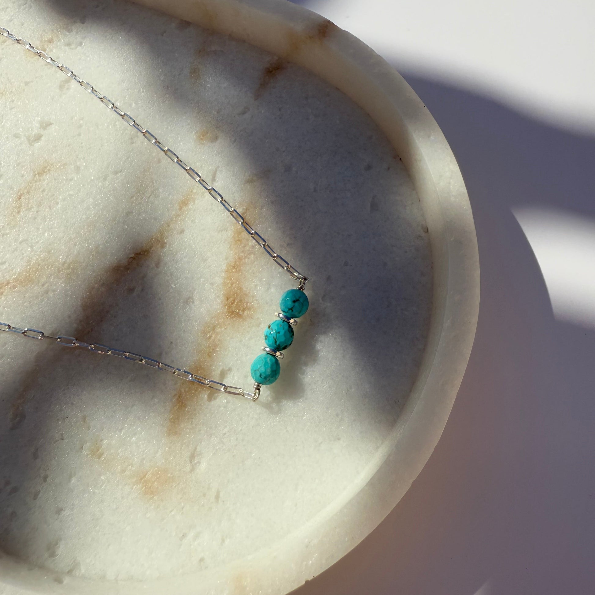 Necklace with turquoise beads on a marble surface